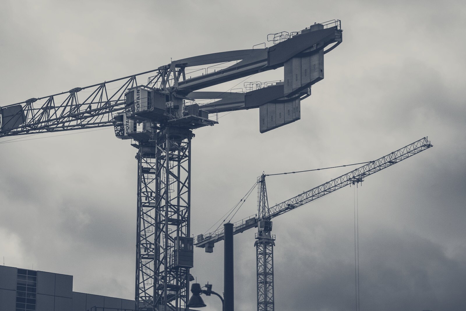 a couple of cranes that are next to a building